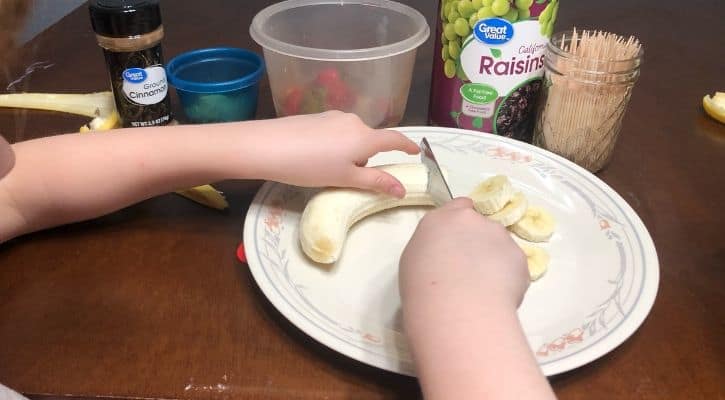 healthy kid freebies, little kid cutting banana with knife by self