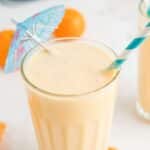 Orange Creamsicle smoothie with teal cocktail umbrella and straw.