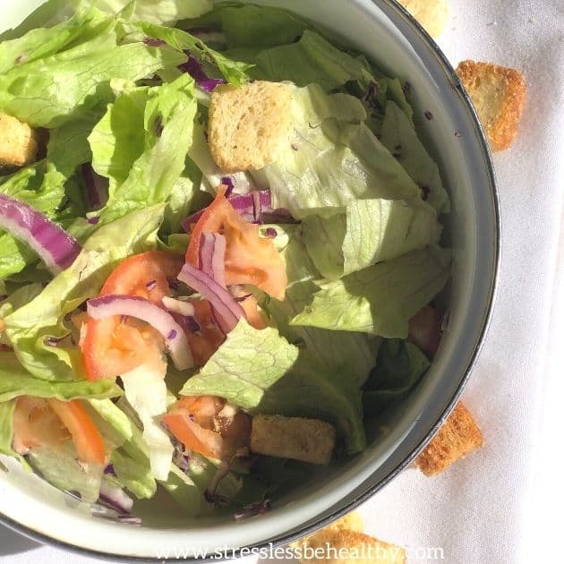 simple salad with lettuce, tomatoes, red onion, croutons, red cabbage