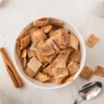 Overhead of homemade vegan cinnamon toast crunch in a bowl without milk, with a spoon to the side.