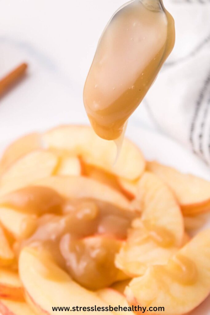 Dairy free caramel sauce being drizzled over sliced apples.