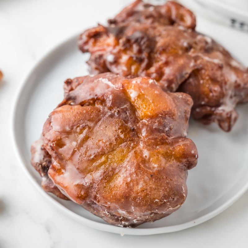 Vegan apple fritters on a white plate.