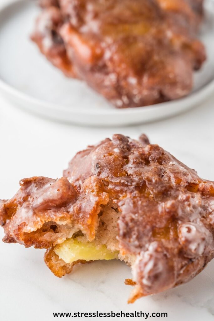 Vegan apple fritters with a bite taken out of it.