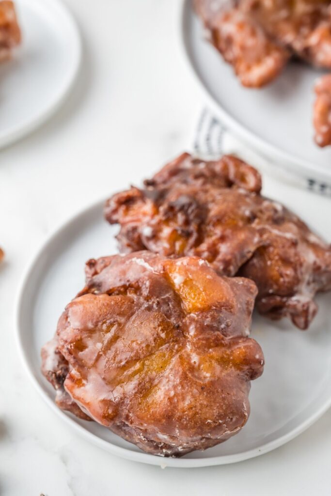 Vegan apple fritters on a white plate.