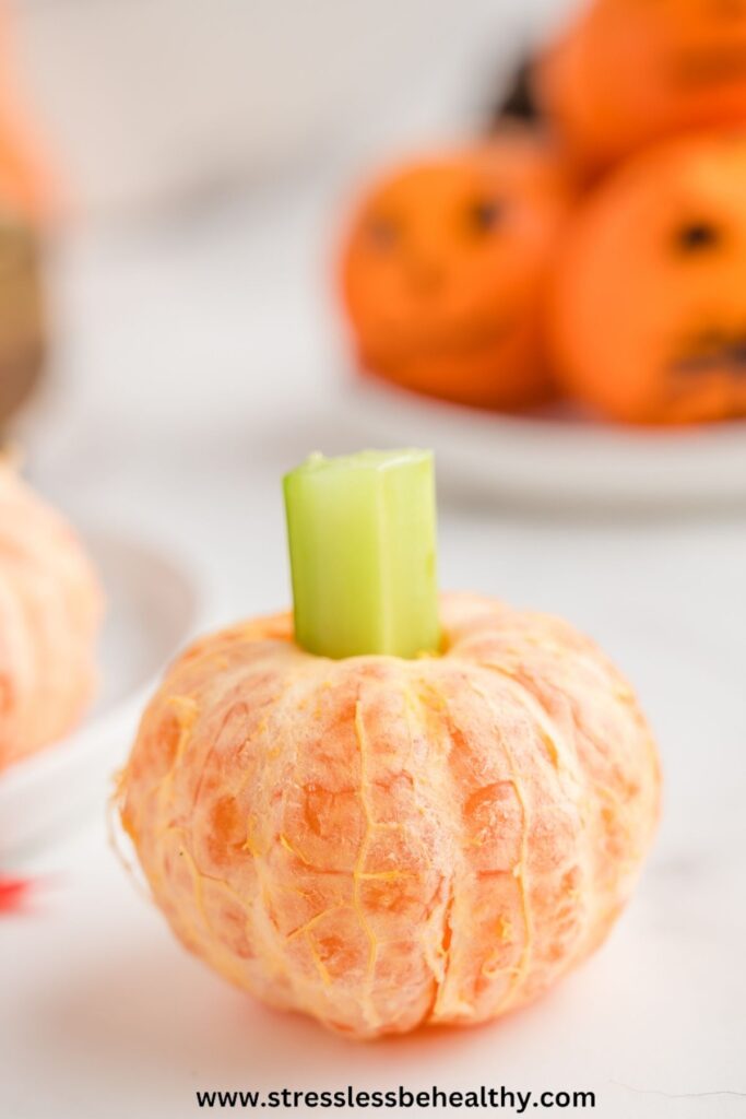 Healthy Halloween food for kids - clementine pumpkins sitting on the counter with more cute pumpkin clementines behind it.