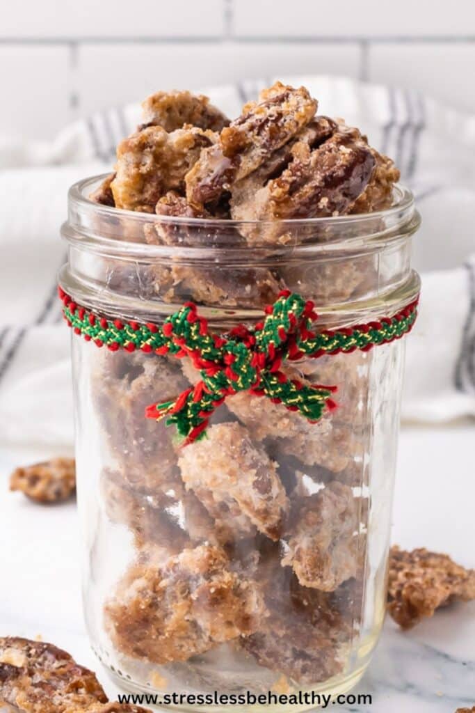 Candied Pecans in a jar with a red and green ribbon.