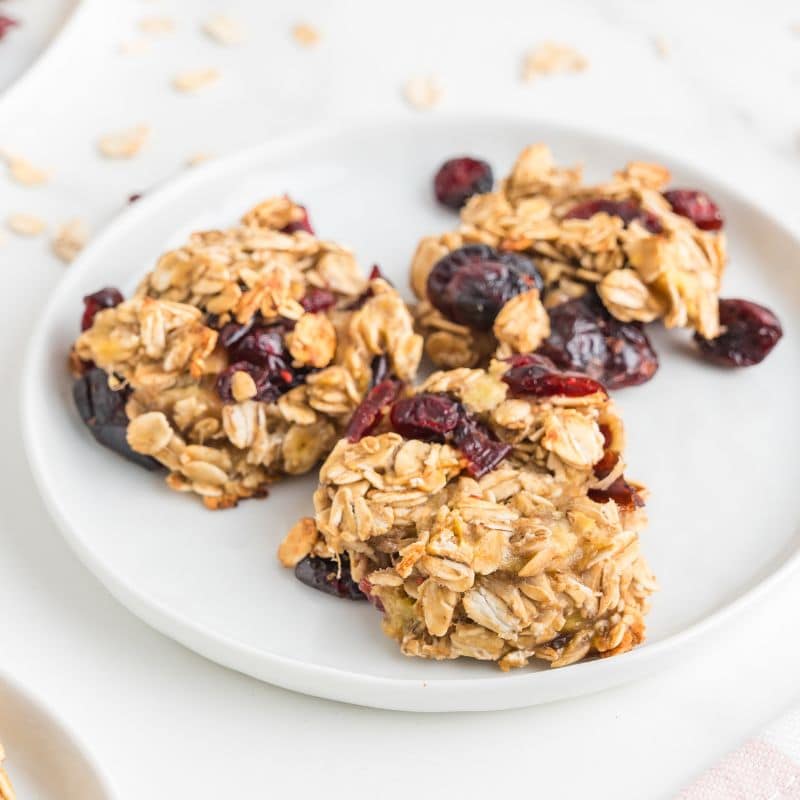 3 Healthy banana oatmeal cranberry cookies on a white plate.