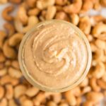 Cashew Butter in a jar with cashews surrounding it.