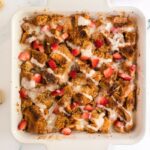 Strawberry french toast casserole with vanilla icing drizzled on top.