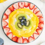 Rainbow No bake Fruit Tart with strawberries, mango, pineapple, kiwi, and blueberries and an animal cracker crust.