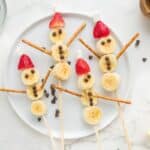 4 banana snowmen on a white plate.