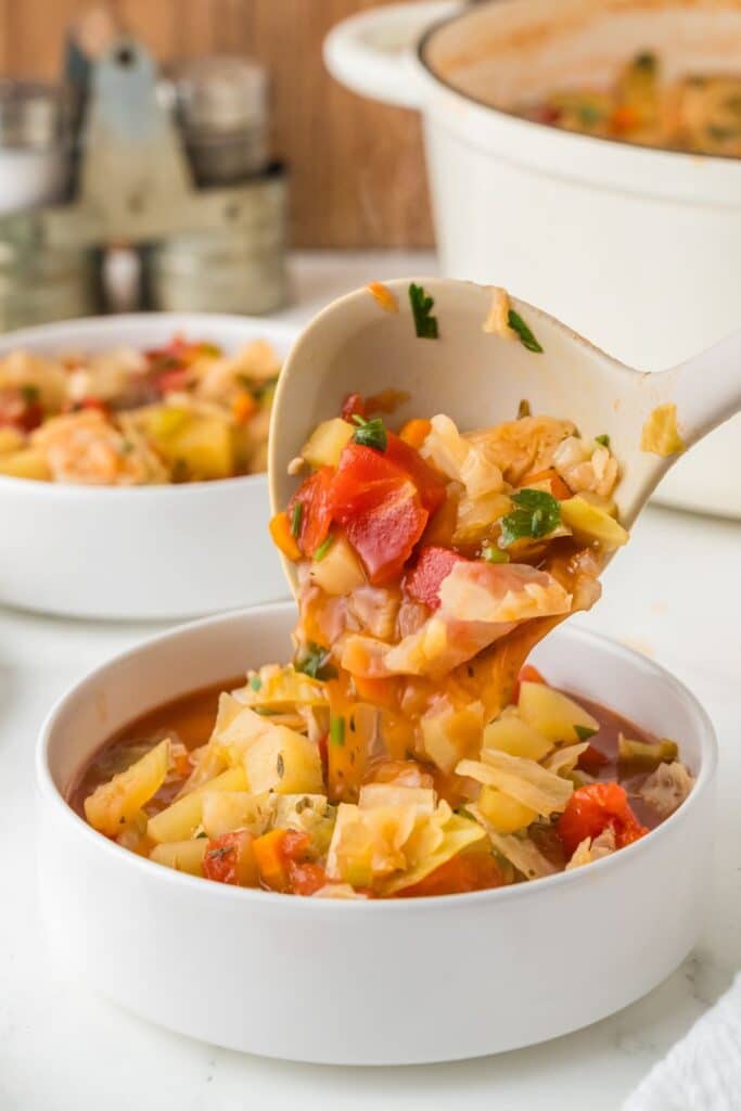 Cabbage Soup being served into a white bowl.